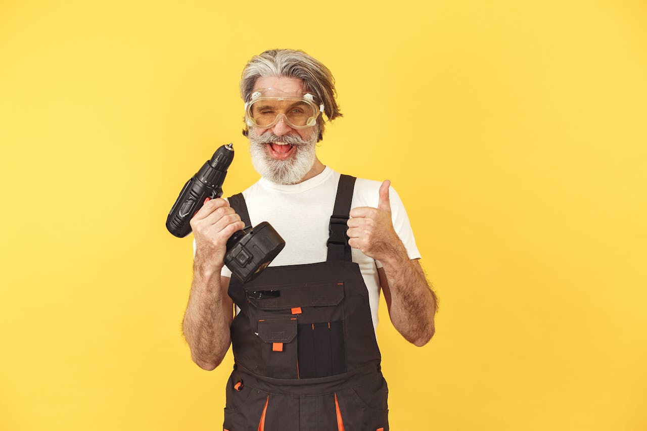 Man Smiling and Holding a Cordless Drill