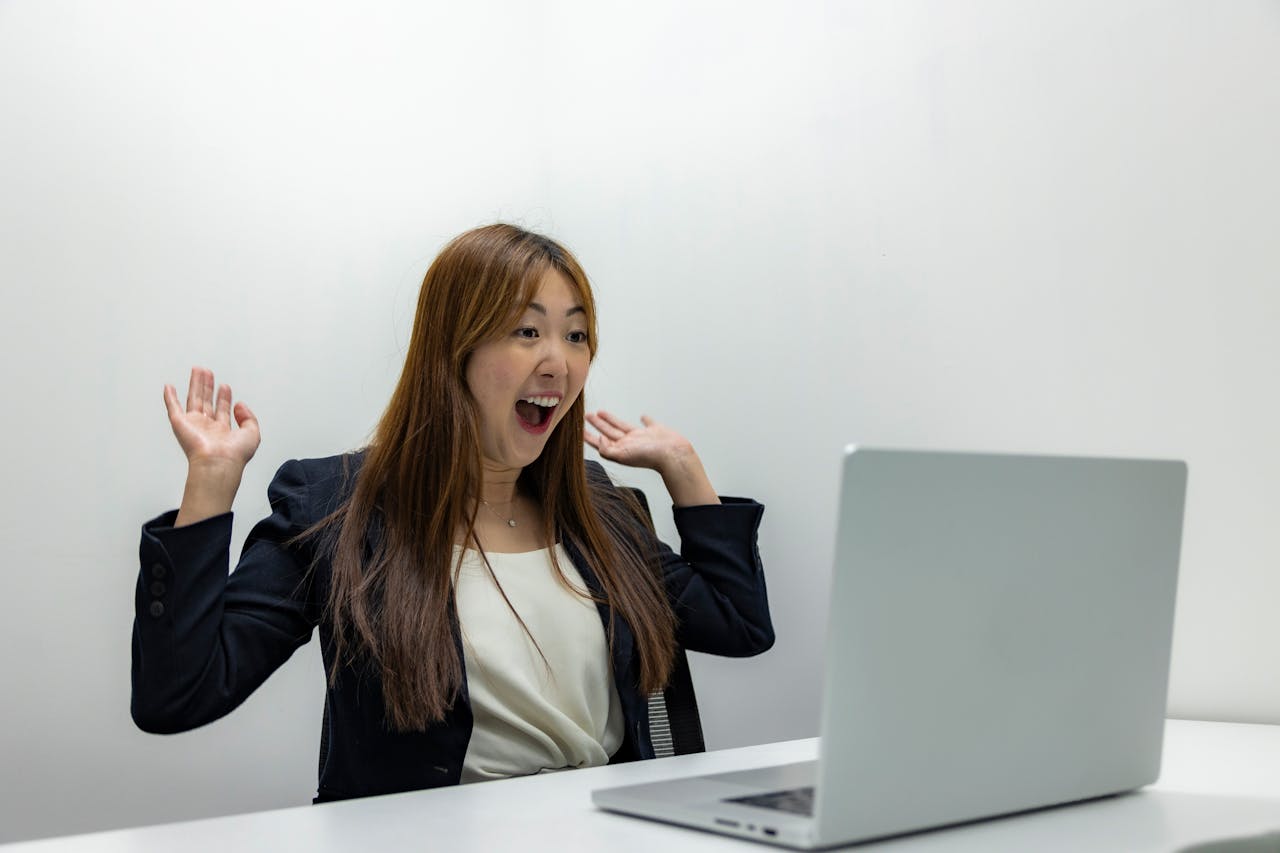 Woman Celebrating in Front of a Laptop