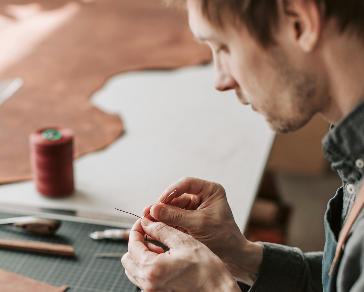 Man in Gray Long Sleeves Working with Leather