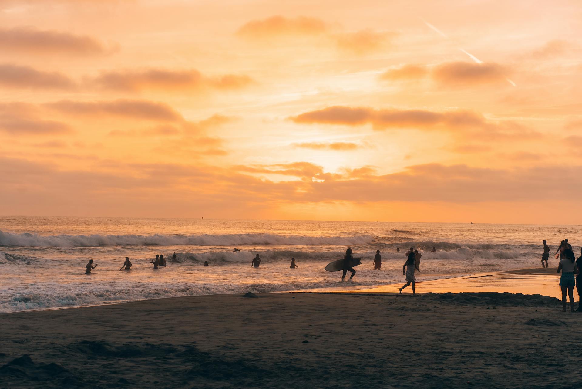 People walking on the beach at sunset