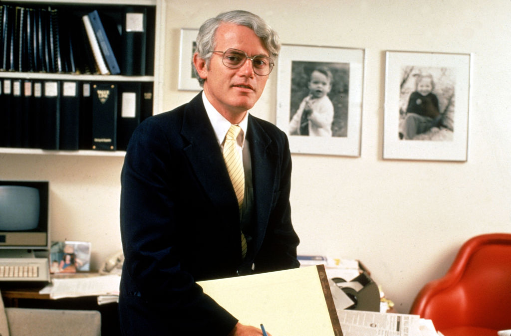 Portrait Photo of Peter Lynch in dark suit sitting at his desk