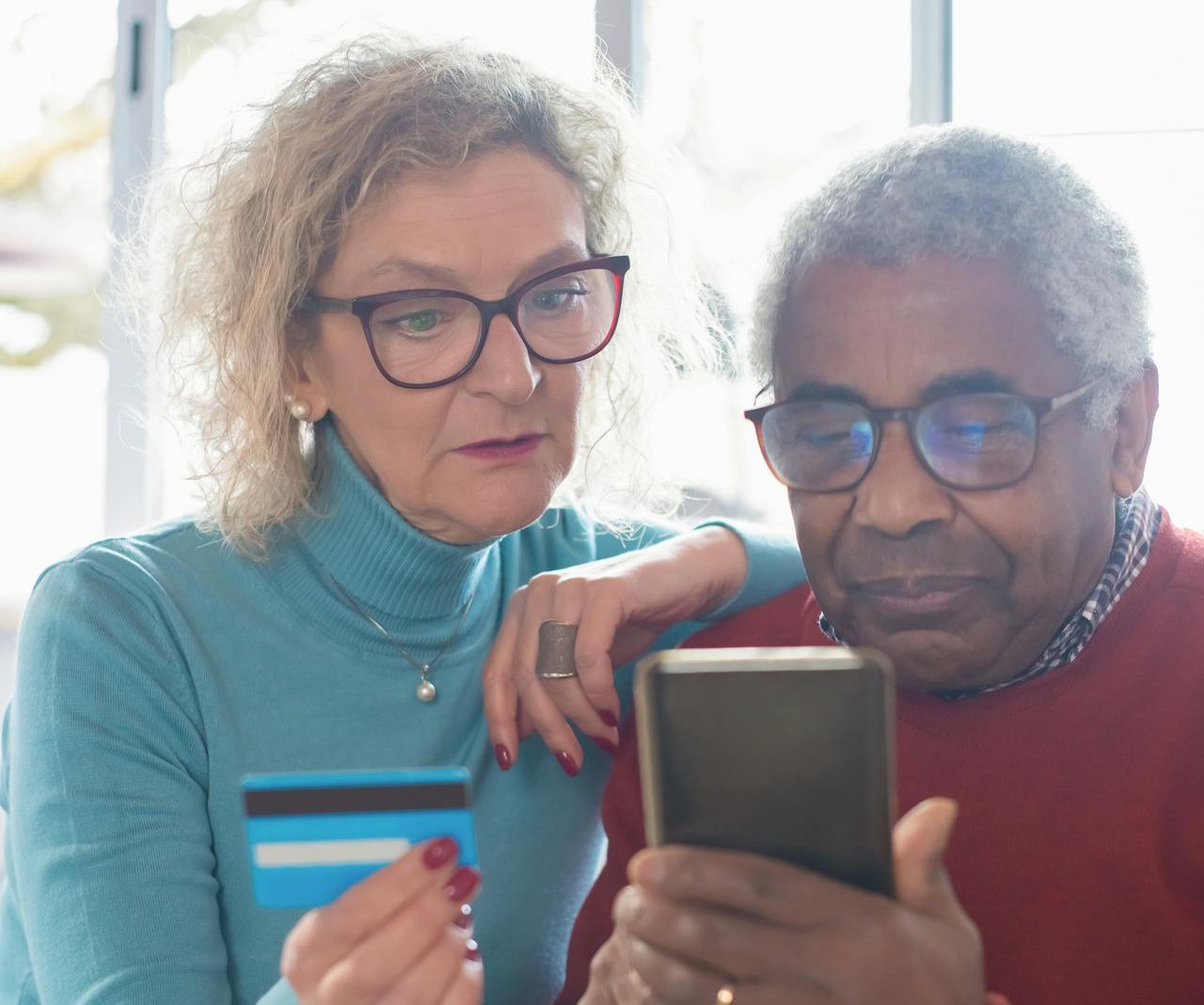 Woman and Man Using Cellphone And a Credit Card Together