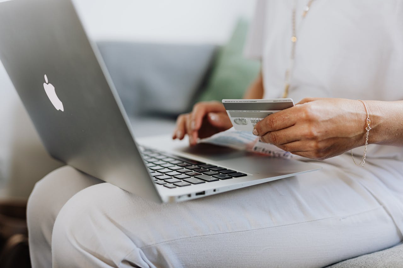 Close Up Photo of Person in White Outfit Using a Macbook
