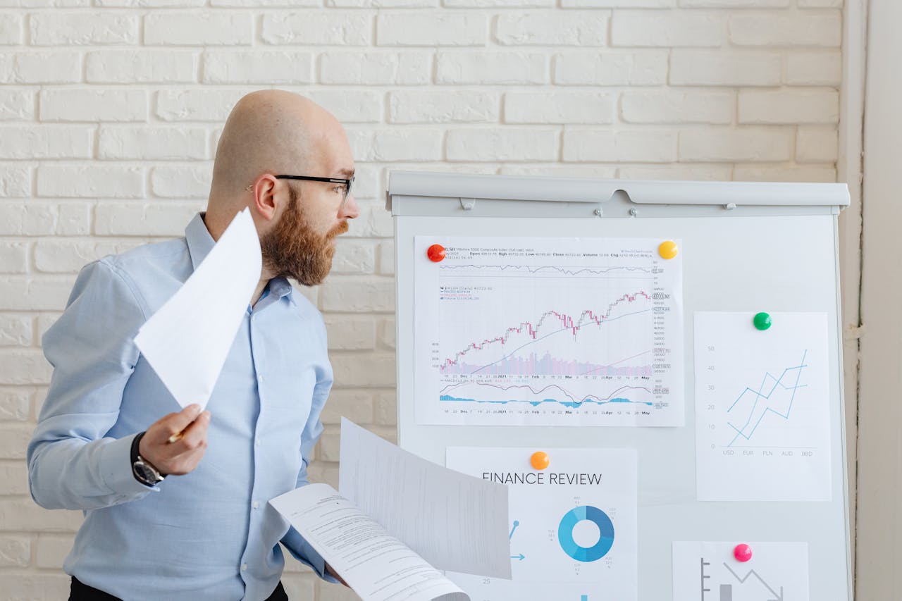 Portrait Photo of A Man in blue shirt Looking at Charts