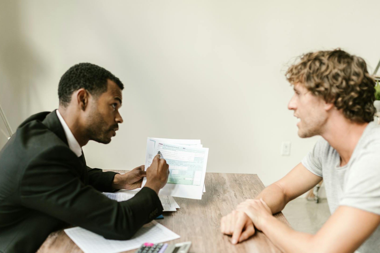 An Agent Showing Documents To His Client