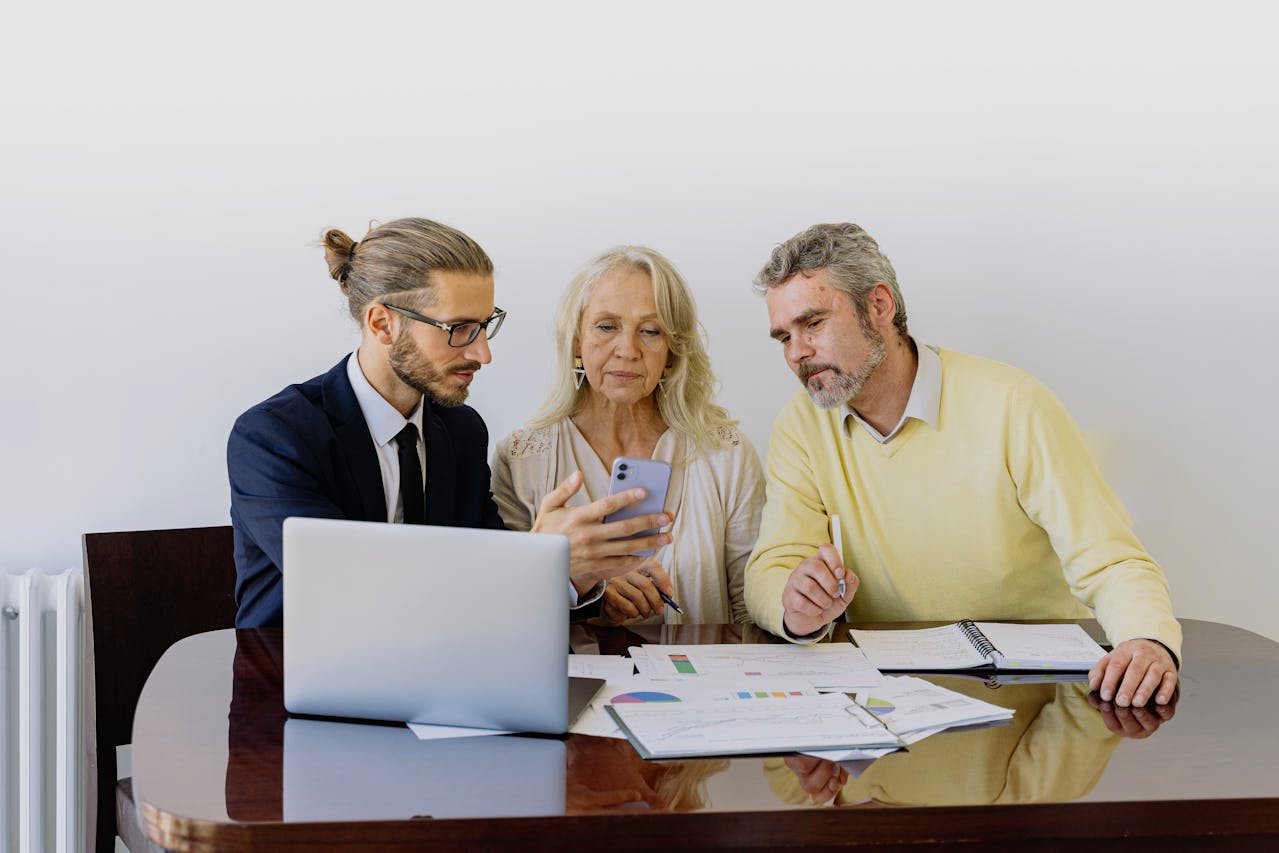 Man in Blue Suit Jacket gives financial advice to elderly couple