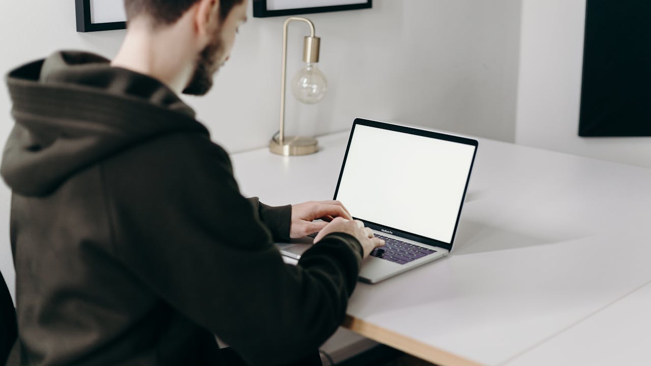 Man in Black Jacket Sitting on a Desk