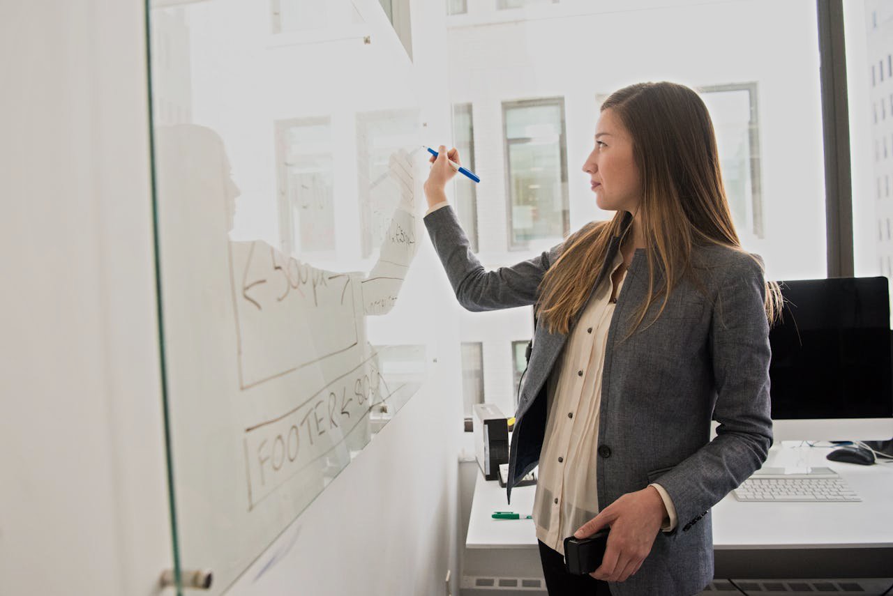 Woman Wearing Gray Blazer Writing