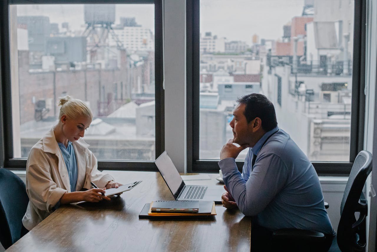 Man In Blue Shirt Sitting In Front Of A Woman