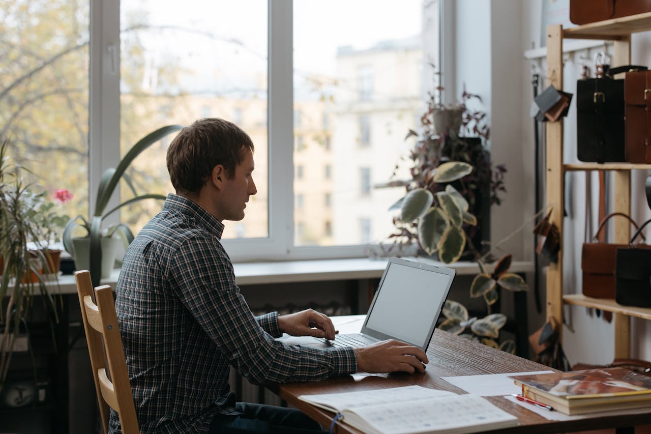 Portrait Photo of A Man Using a Laptop at Home