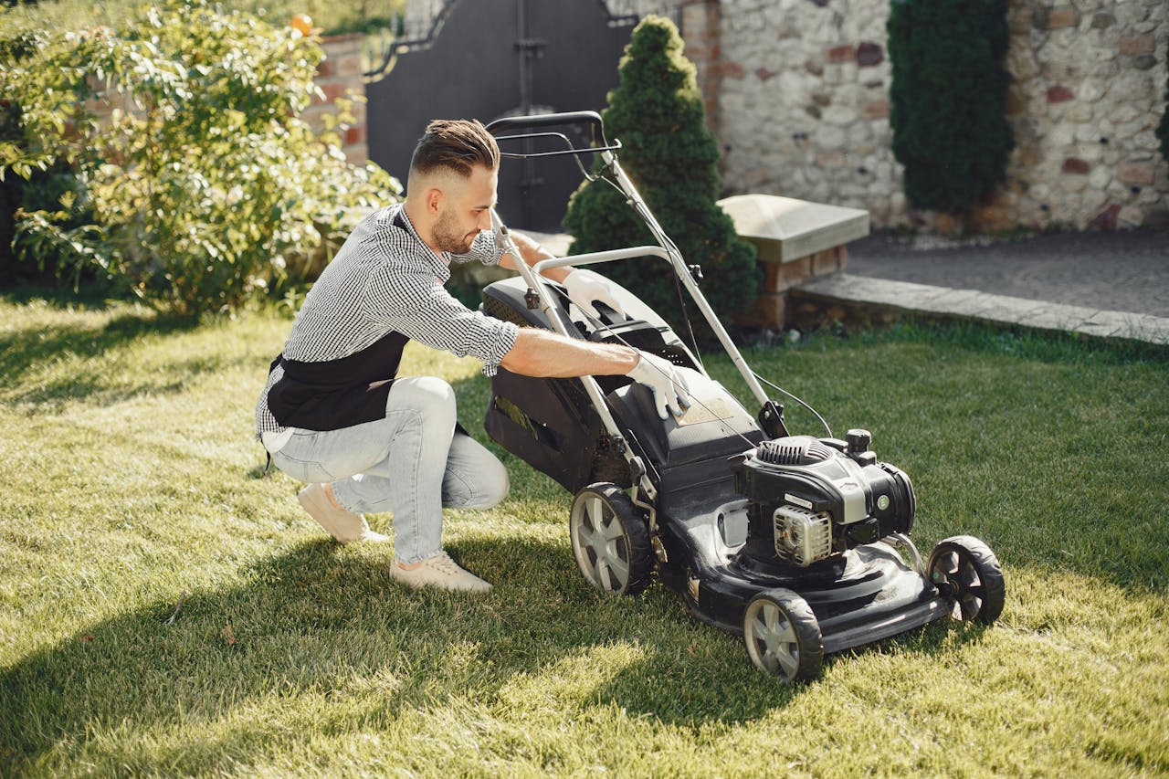 Man Sitting beside Black Grass Cutter