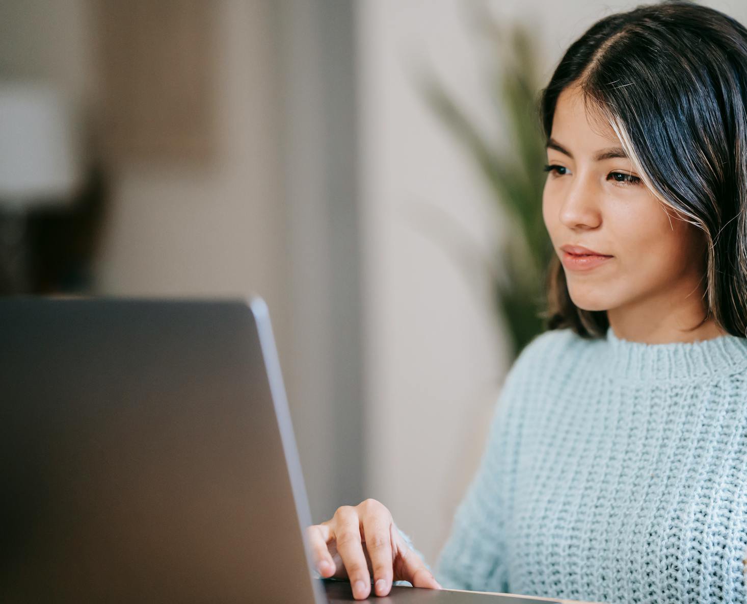 Portrait Photo of Young Woman Using A Laptop at home