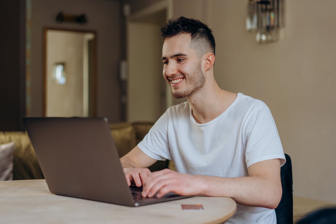 Portrait Photo of a Man Using Laptop at Home