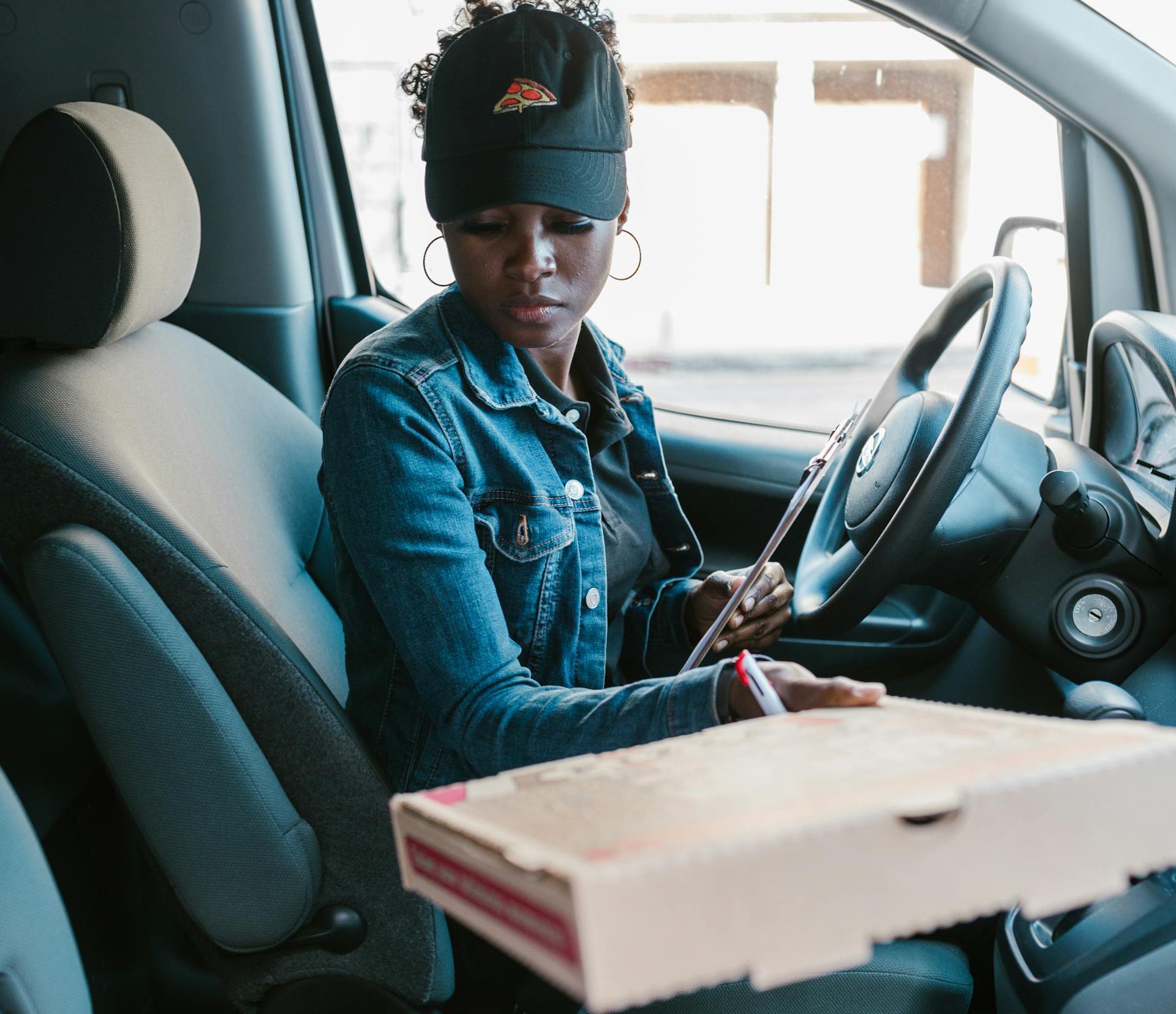 Portrait Photo of A Pizza Deliverywoman sitting in a car