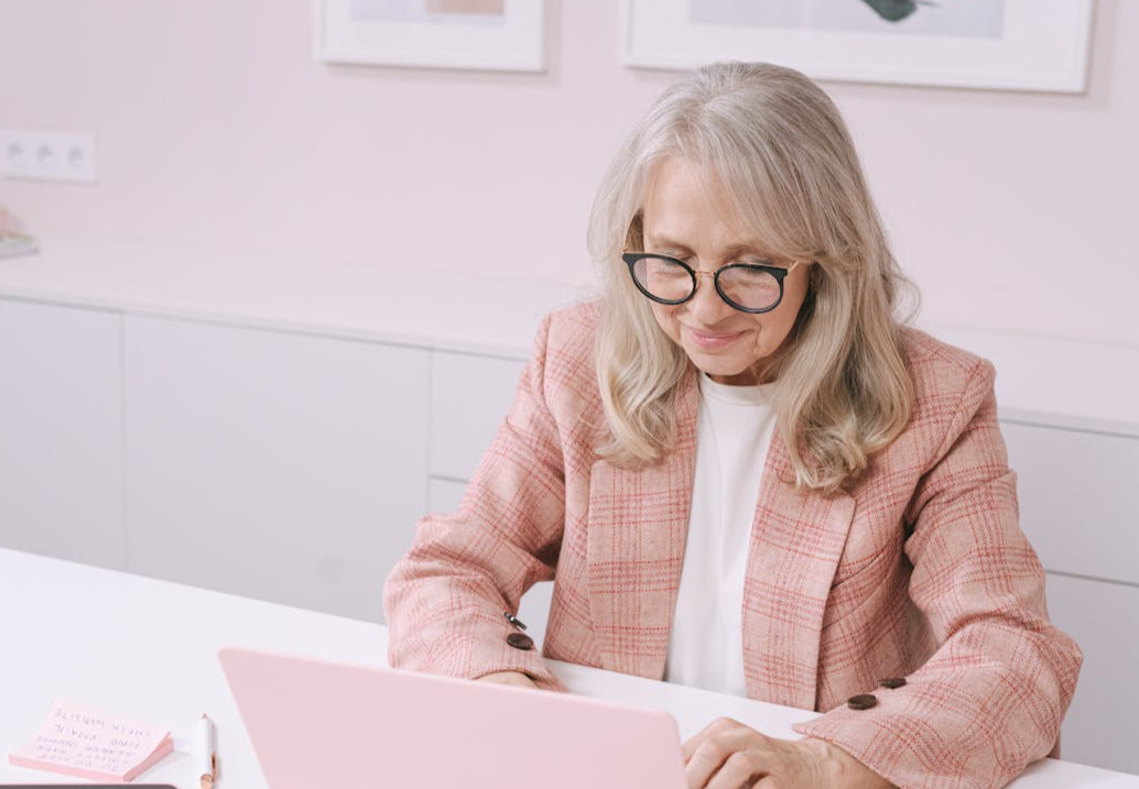 Woman in Eyeglasses Using Laptop on White Table