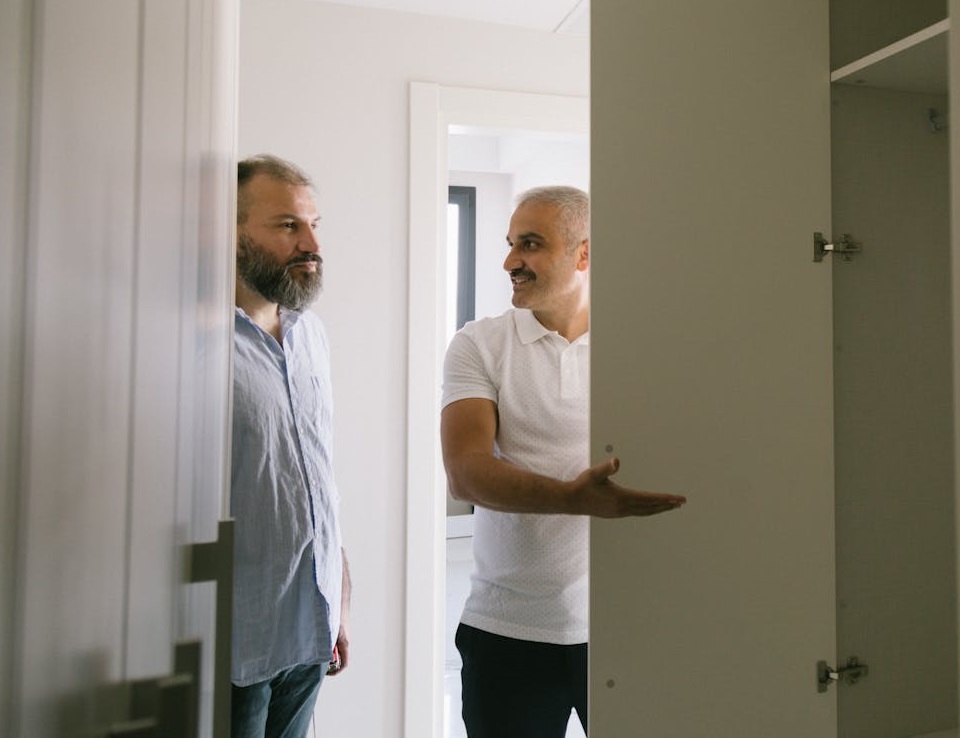 Man is showing a room to other man.