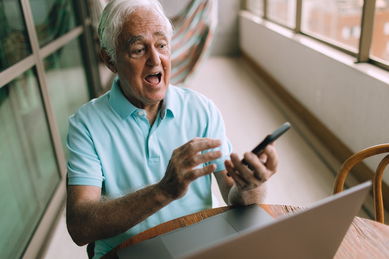 Elderly Man with Laptop and Smartphone