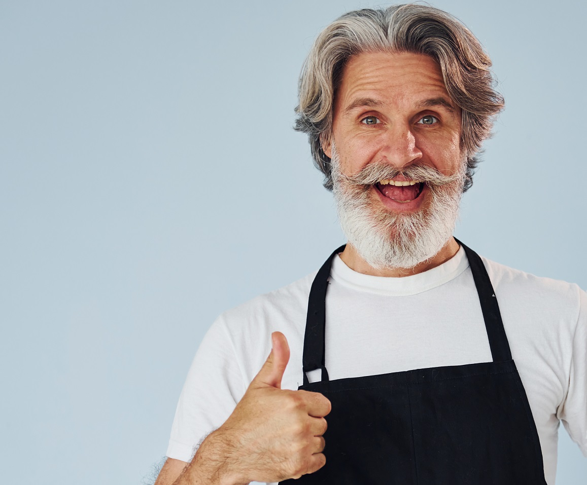 Senior stylish modern man with grey hair and beard indoors.