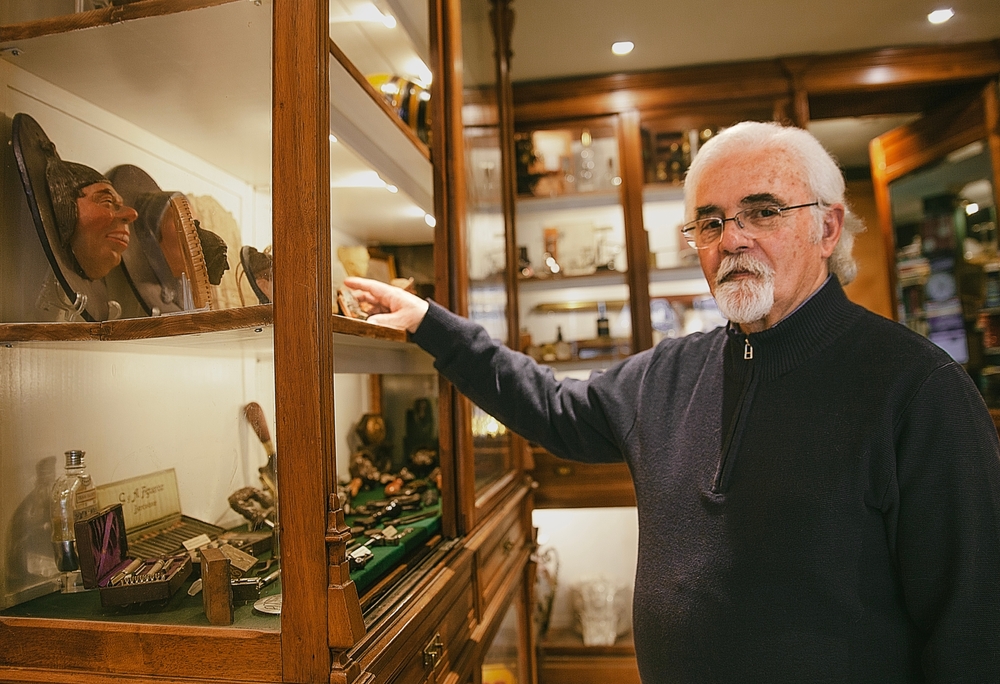 An elderly owner of an antique store in the interior of his store