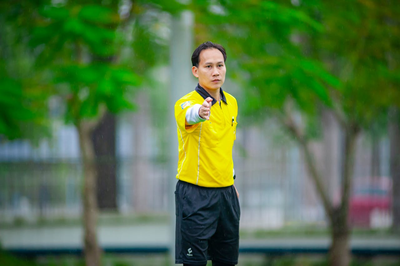 Man in Referee Outfit in Action During Soccer Match