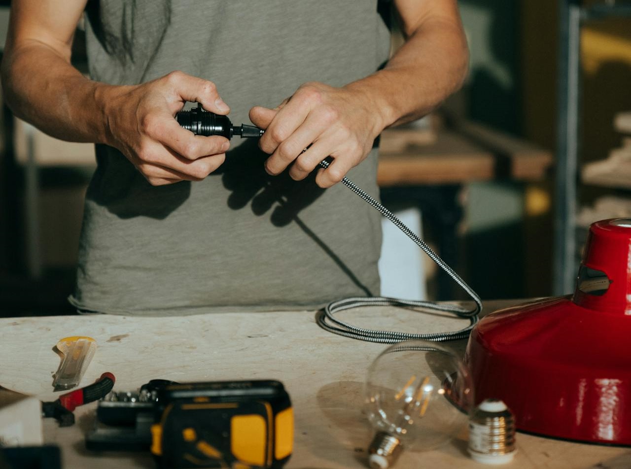 Man in Gray Crew Neck T-shirt Holding Black and Silver Hand Tool