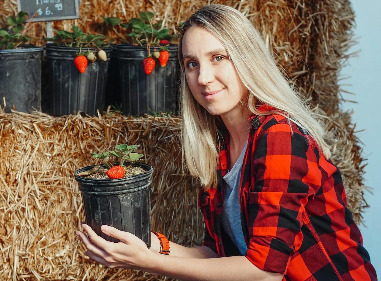 Close-Up Shot of a Woman Holding Potted Strawberry Plants