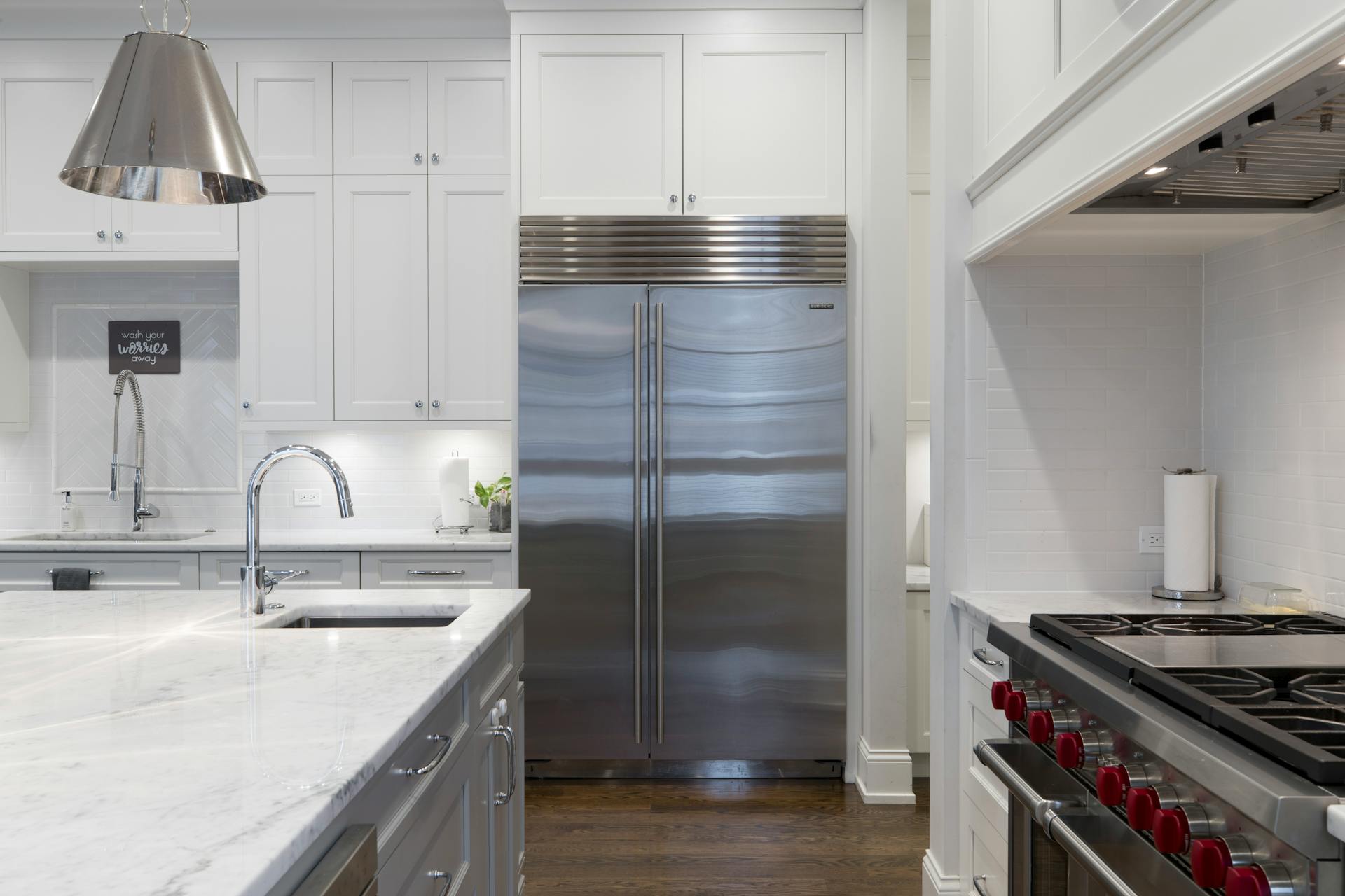 Stainless Steel Refrigerator Besides White Kitchen Cabinet