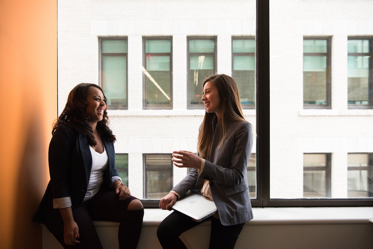 Two girls talking in hallway.