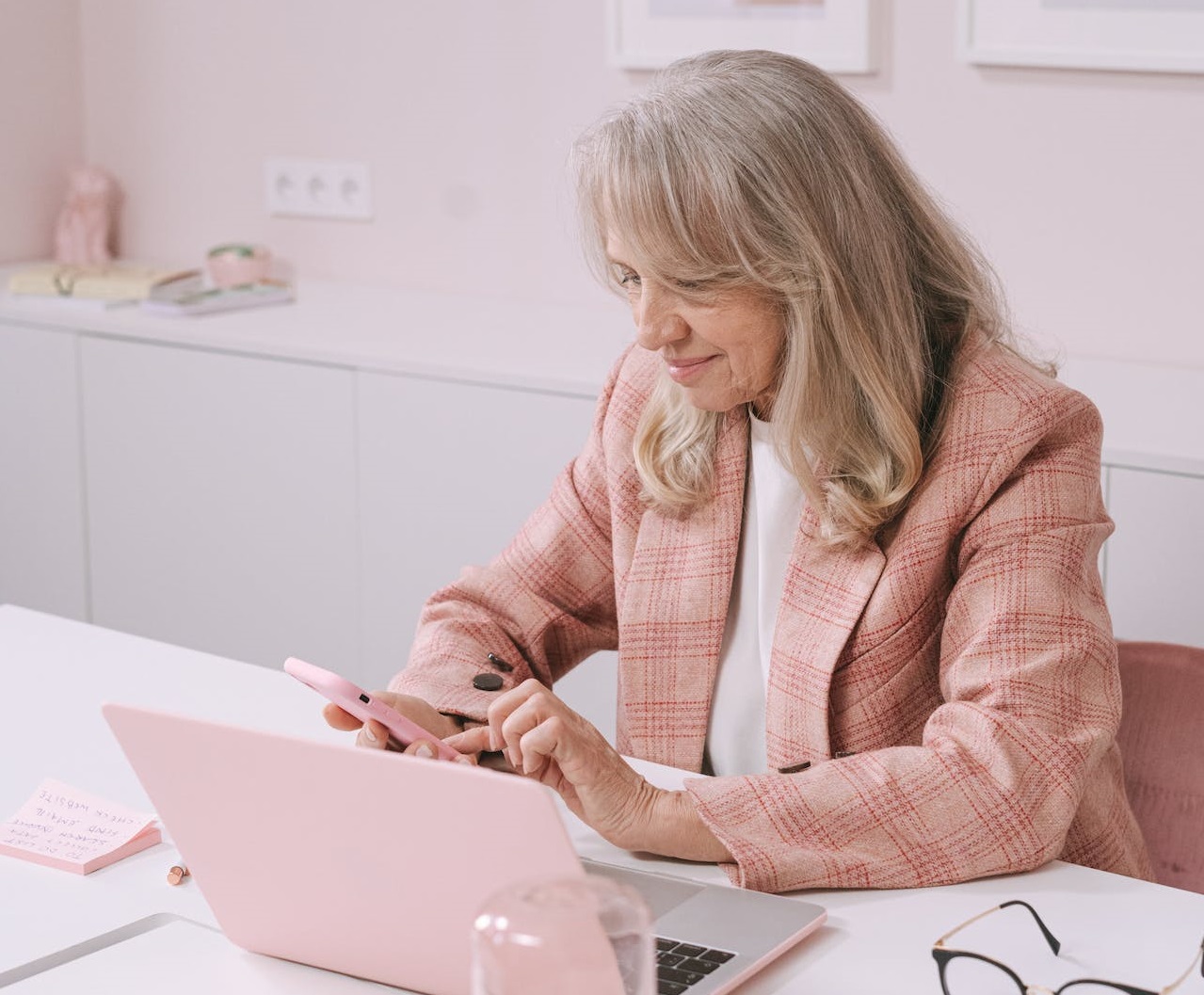 Woman is working in her pink office.
