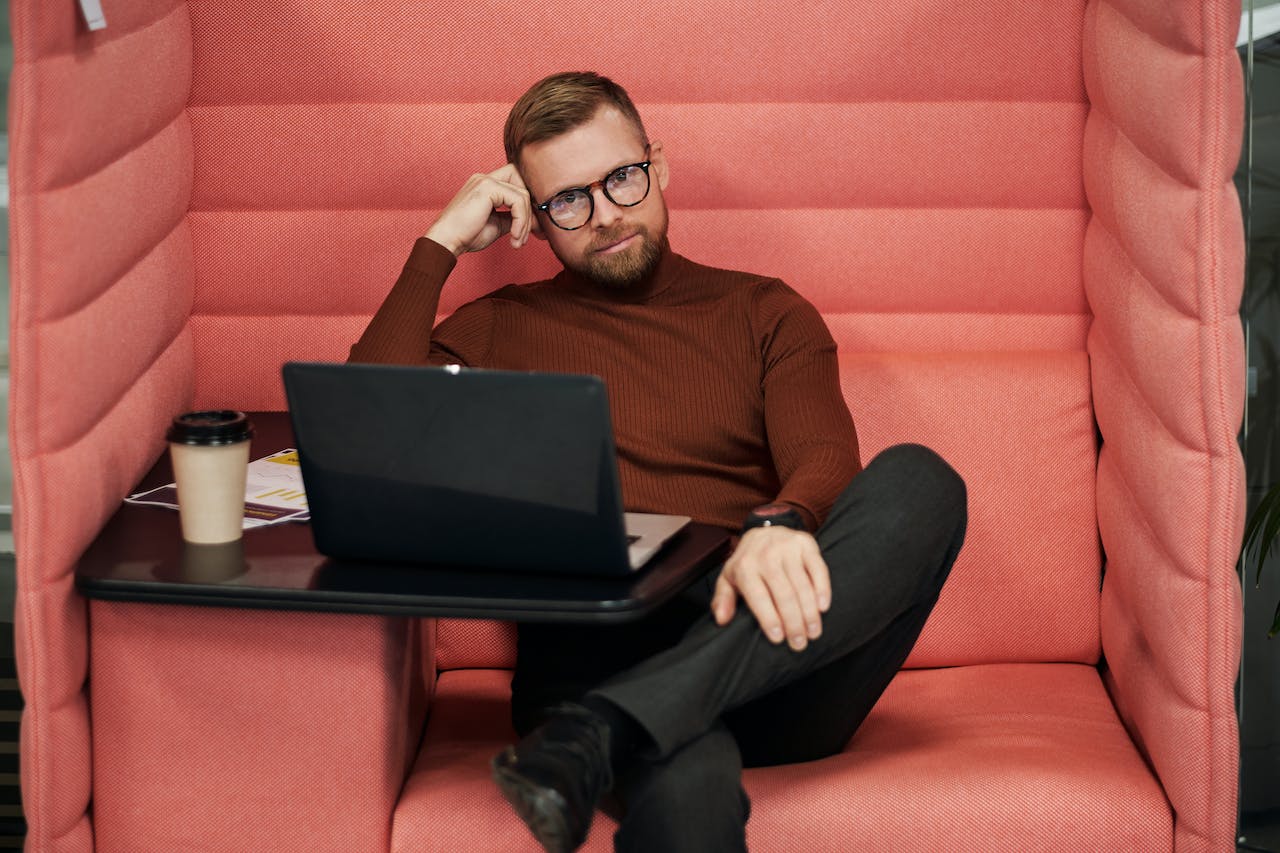 Young man is seating in red boot and thinking.
