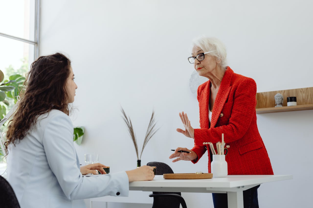 Two woman are talking in the office.