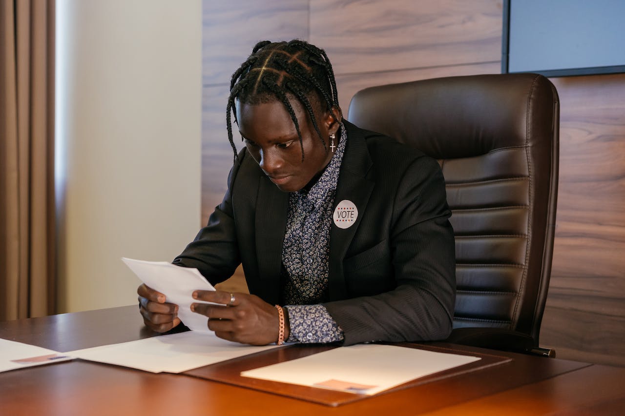 Man seating at his desk and reading a document.