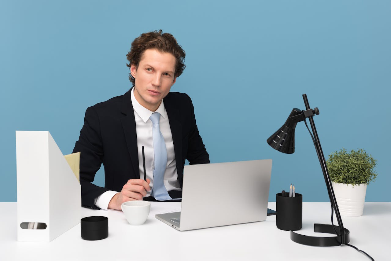 Man in suit is seating on his desk and thinking.