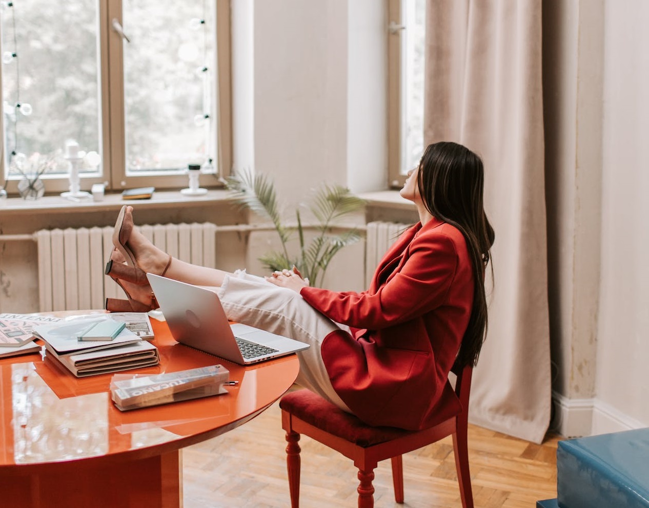 Woman is relaxing with legs on her office desk.