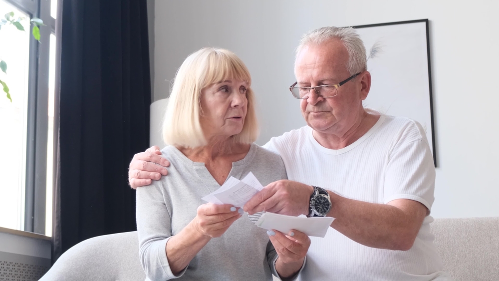 Serious elderly husband and wife review utility bills