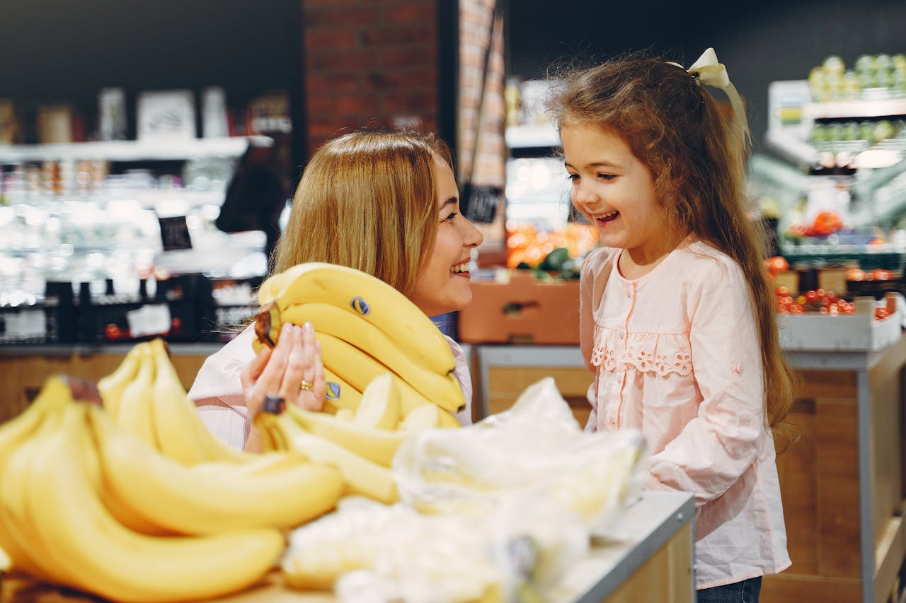 Mother and daughter buying bananas.