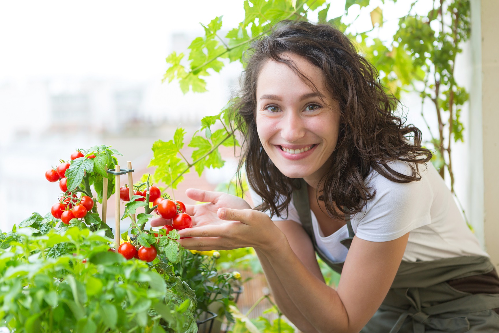 Woman with plants and vegetables on her balcony.