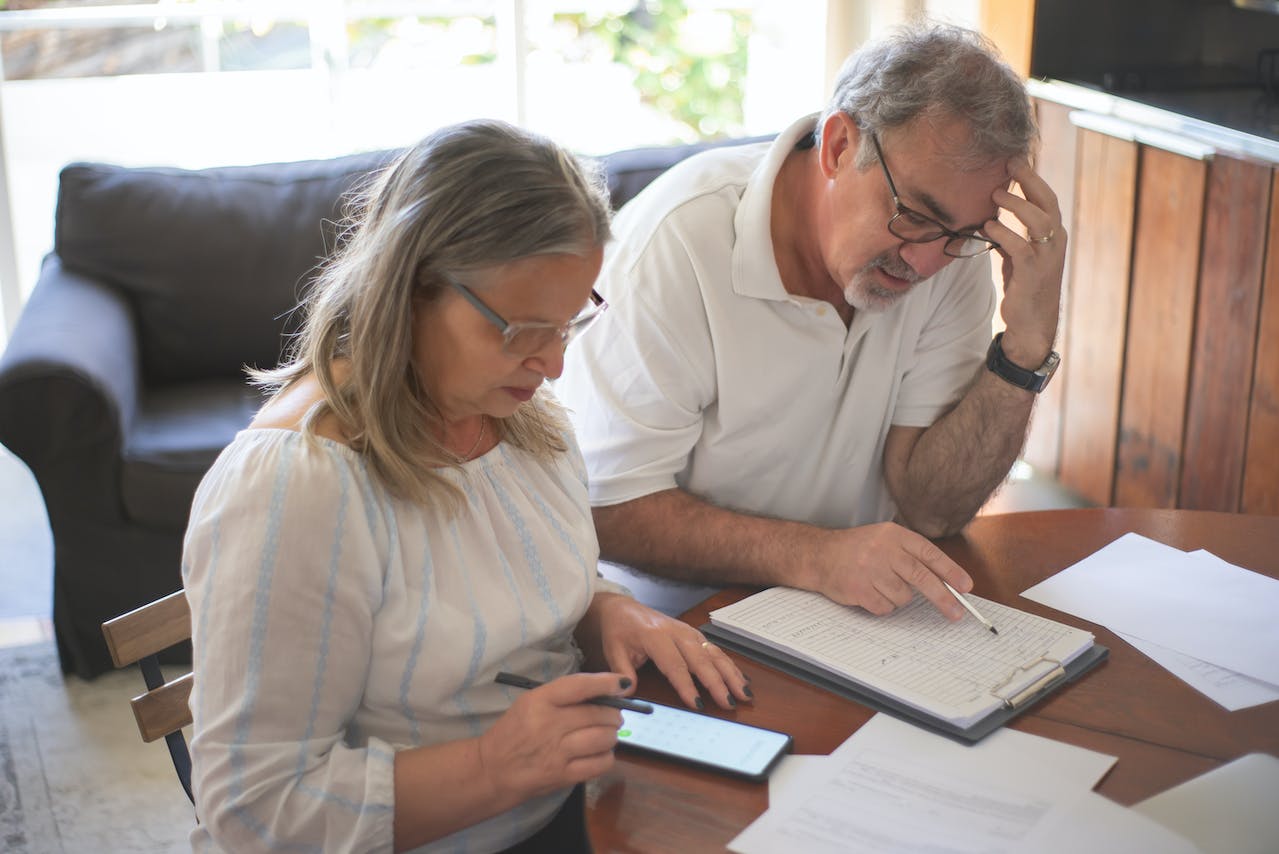 Elderly couple sitting at the table with documents.