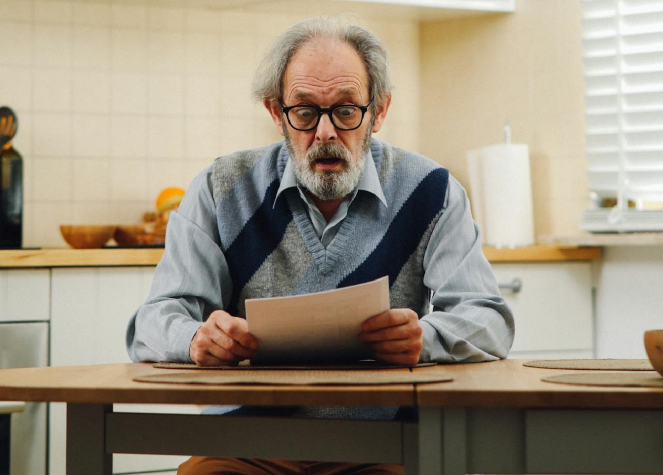 A man is sitting at a table with a piece of paper.