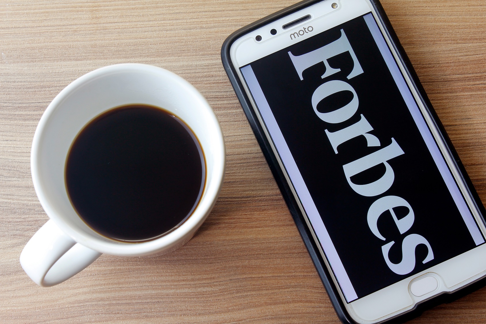 Forbes logo on the smartphone screen.