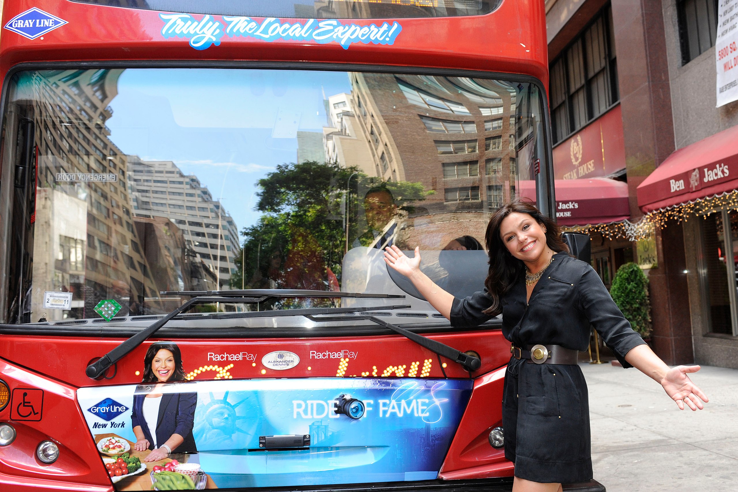 Rachael Ray posing next to her personalized decal in front of a double-decker bus - 2010