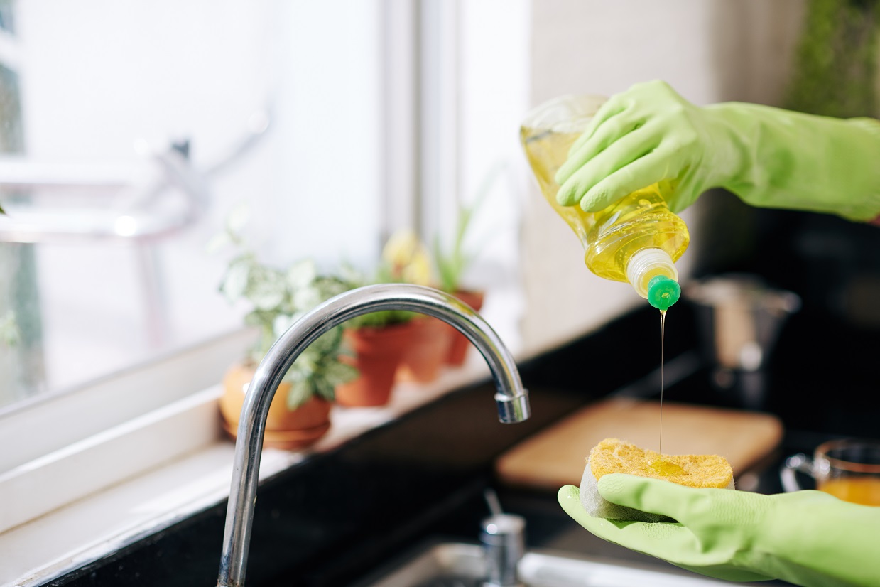 woman in latex gloves washing dishes