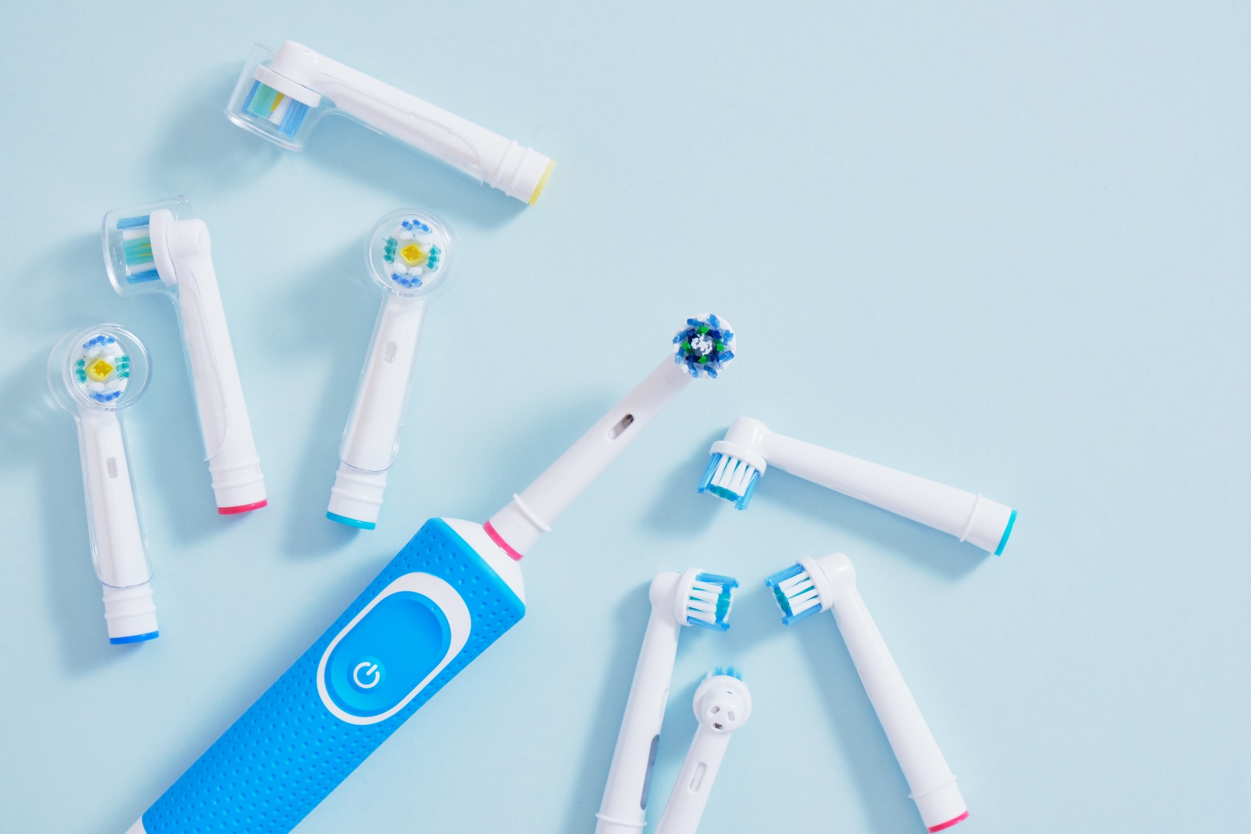 electric toothbrush and a lot of different multi-colored replaceable nozzles