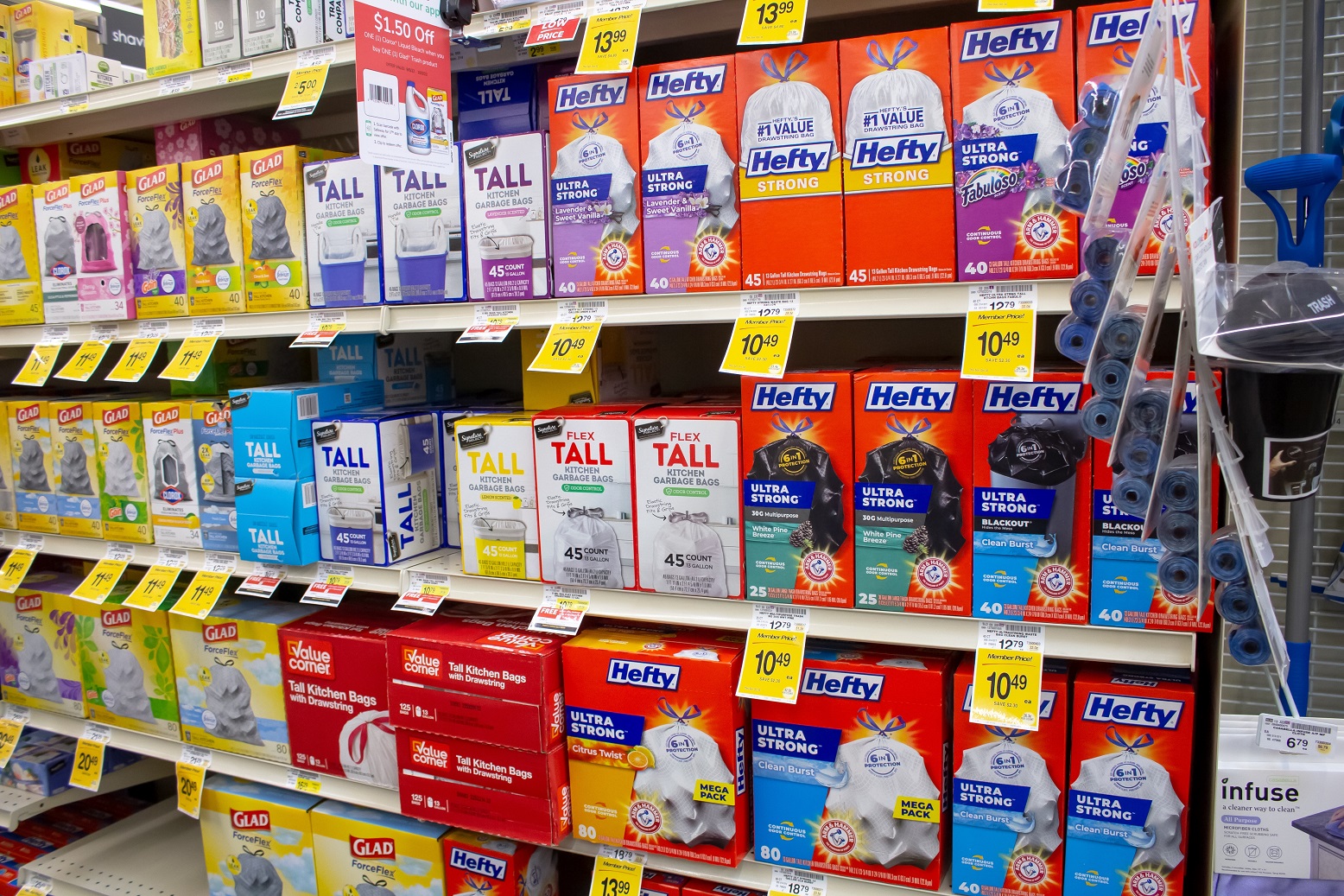 A view of several shelves dedicated to trash bag packages, on display at a local retail store.