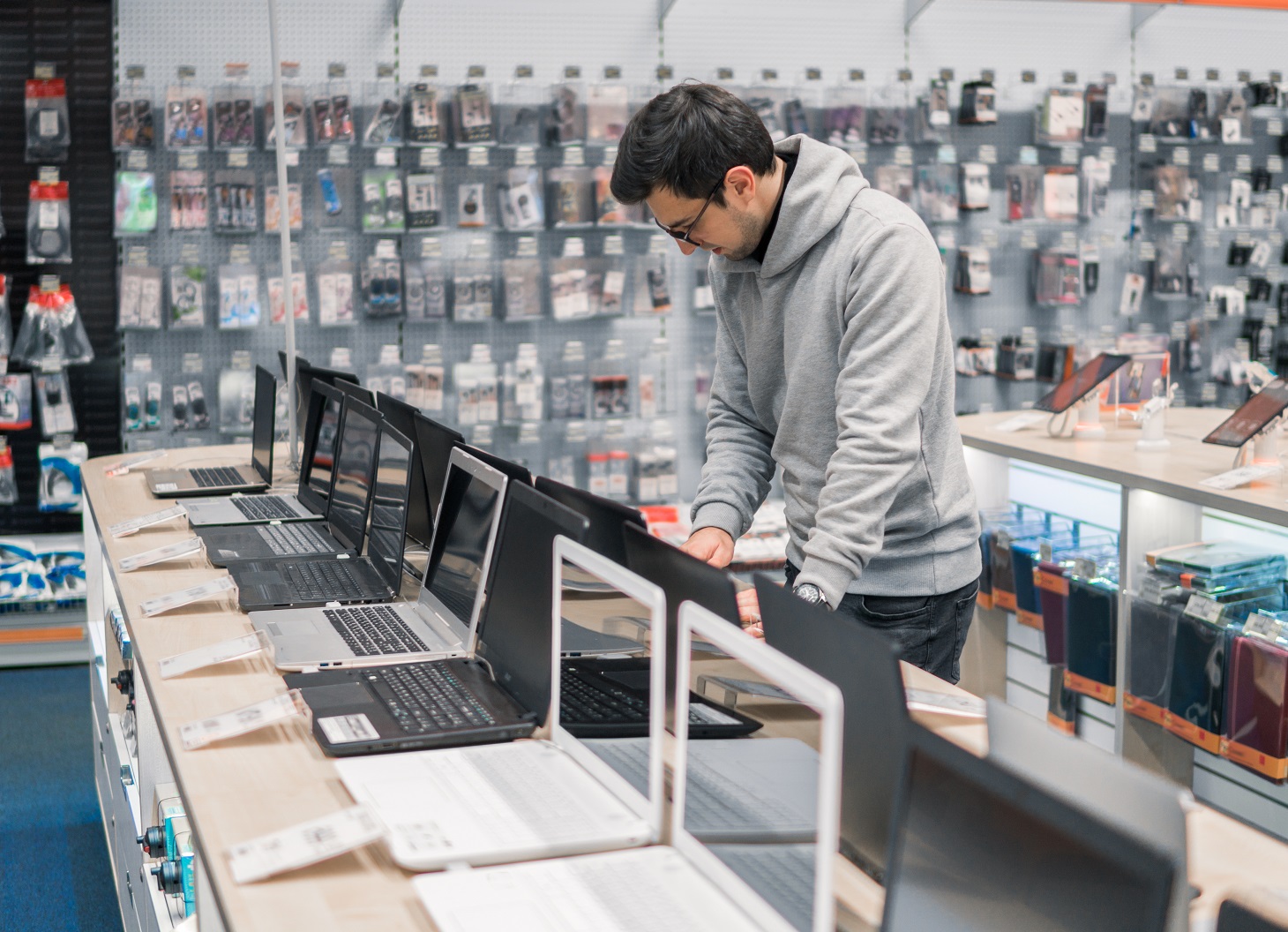 Smart modern male customer choosing laptop in the computer store.