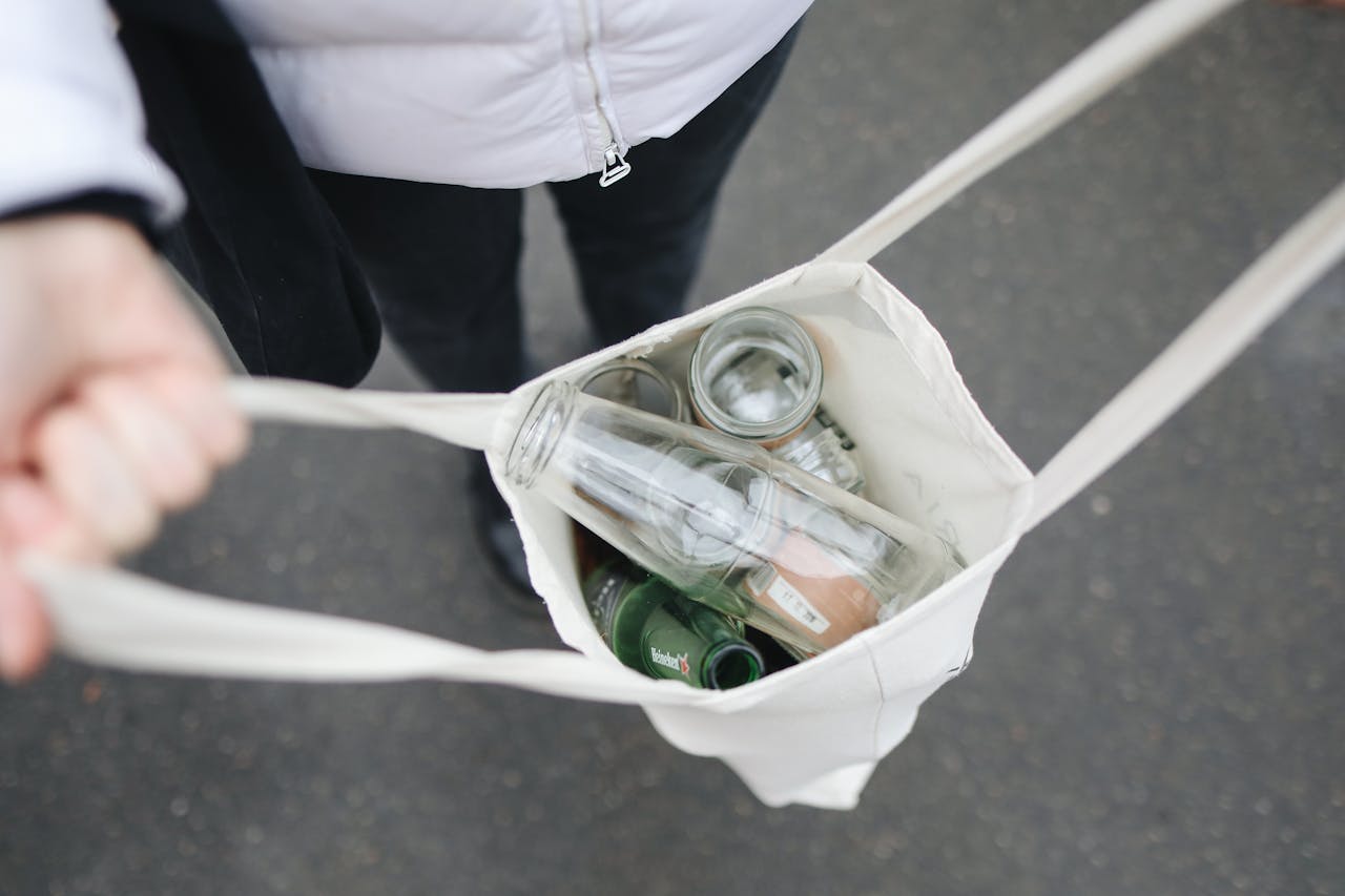 Person holding a bag with glass bottles