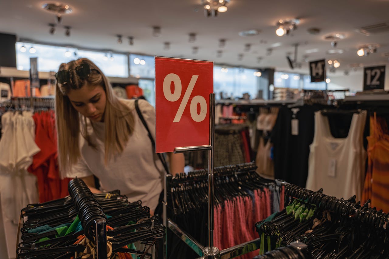 Young Woman Browsing Clothes on Sale in a big clothing store