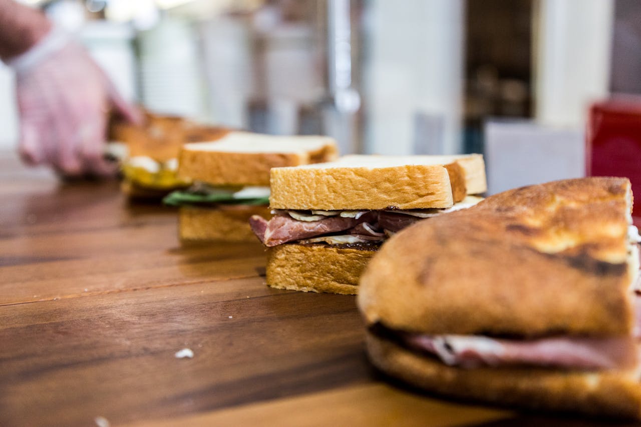 Lined up sandwiches on brown wooden table