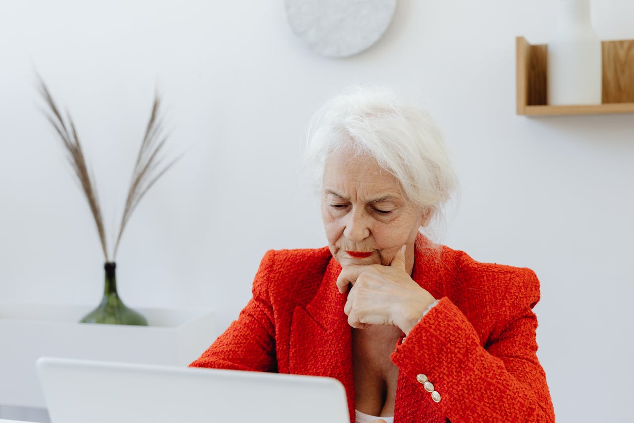Elderly woman wearing red-blazer while working in the office