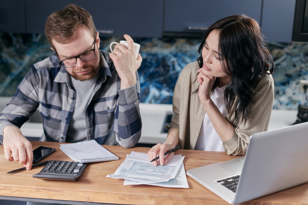 Man and woman sitting next to each other looking at document papers